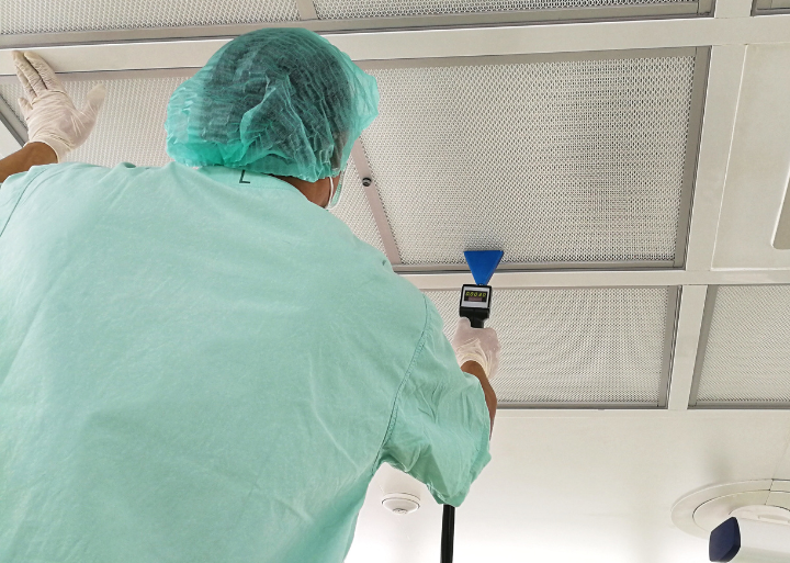 Air check Person in scrubs running an air test on a ceiling.